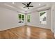 Bright bedroom features hardwood floors, a tray ceiling with recessed lighting, and large windows with backyard views at 2553 Creekwood Ter, Decatur, GA 30030