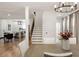 Open-concept dining room with hardwood floors, modern chandelier, and access to the kitchen and staircase at 2553 Creekwood Ter, Decatur, GA 30030