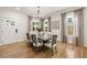 Elegant dining room with a modern chandelier, hardwood floors, and soft neutral window coverings at 2553 Creekwood Ter, Decatur, GA 30030