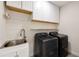 Well-equipped laundry room featuring a modern washer and dryer, sink, and ample storage cabinets at 2553 Creekwood Ter, Decatur, GA 30030