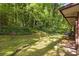 Lush backyard featuring a grassy area, mature trees, and exterior view of the house at 470 Hunnicutt Se Rd, Mableton, GA 30126