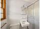 Clean bathroom with white tiles, sink, toilet, and glass shower, complemented by a wood framed window at 470 Hunnicutt Se Rd, Mableton, GA 30126