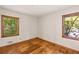 Bedroom features gleaming hardwood floors, two bright windows, and white walls at 470 Hunnicutt Se Rd, Mableton, GA 30126