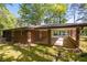 Back exterior view of the home showcasing a brick facade, connected carport and a well-maintained lawn at 470 Hunnicutt Se Rd, Mableton, GA 30126