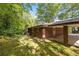 Exterior view showing brick facade, lawn, and mature trees providing shade and a serene atmosphere at 470 Hunnicutt Se Rd, Mableton, GA 30126