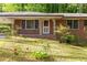 A lovely brick home's entrance has decorative iron porch supports and mature shrubs adorning the front yard at 470 Hunnicutt Se Rd, Mableton, GA 30126