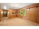 A cozy living room with wood paneling, a view from the window, and connected to the kitchen at 470 Hunnicutt Se Rd, Mableton, GA 30126