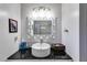 Bright bathroom featuring a round sink, decorative mirror and a dark countertop at 1189 Norfolk Nw Dr, Acworth, GA 30102