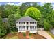 Charming two-story home featuring double porches, black shutters, and a lush, landscaped front yard with mature trees at 2870 Abbottswell Dr, Alpharetta, GA 30022