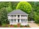 Charming two-story home featuring double porches, black shutters, and a lush, landscaped front yard with mature trees at 2870 Abbottswell Dr, Alpharetta, GA 30022