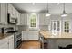 Bright, updated kitchen with white cabinets, granite countertops, stainless steel appliances, and an island with seating at 2870 Abbottswell Dr, Alpharetta, GA 30022
