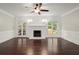 Bright living room with fireplace, French doors, dark wood floors and wainscoting at 2870 Abbottswell Dr, Alpharetta, GA 30022