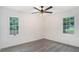 Bright bedroom with gray flooring, two windows, and a stylish ceiling fan at 3132 Lunsford Cir, Covington, GA 30014