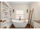 Bright bathroom highlighting the soaking tub, built-in shelves, wood floors and a decorative ladder feature at 6250 Bannerhorn Run, Alpharetta, GA 30005