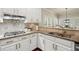 Close-up of kitchen with granite countertops, stainless appliances, and white cabinetry at 6250 Bannerhorn Run, Alpharetta, GA 30005