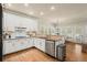 Open kitchen with hardwood floors, granite countertops, stainless appliances, and white cabinetry at 6250 Bannerhorn Run, Alpharetta, GA 30005