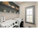 Laundry room with modern washer and dryer and window at 6250 Bannerhorn Run, Alpharetta, GA 30005