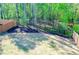 Wide shot of backyard features a black fence, mulch, grass and trees at 660 Stately Dr, Woodstock, GA 30188