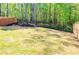 Large, grassy backyard with a wooded backdrop and modern fencing for privacy at 660 Stately Dr, Woodstock, GA 30188