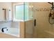 Bright bathroom featuring a soaking tub and glass-enclosed shower with decorative tile accents and modern fixtures at 660 Stately Dr, Woodstock, GA 30188
