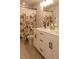 Bathroom features double sink vanity with dark hardware and a shower with a floral curtain at 660 Stately Dr, Woodstock, GA 30188