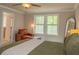Cozy bedroom featuring a large window, a leather chair with an ottoman, and a ceiling fan at 660 Stately Dr, Woodstock, GA 30188