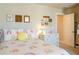 This bedroom features rainbow bedding, small decor, and a dresser at 660 Stately Dr, Woodstock, GA 30188