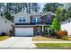 Beautiful two-story home featuring a stone facade, manicured lawn, and a two-car garage at 660 Stately Dr, Woodstock, GA 30188