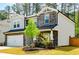 Charming two-story home with a stone facade, well-maintained lawn, and attached two-car garage at 660 Stately Dr, Woodstock, GA 30188
