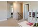 Upstairs hallway features neutral walls, carpet, a small staircase and reading area at 660 Stately Dr, Woodstock, GA 30188