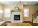 Cozy living room with a fireplace, hardwood floors, and natural light from the windows at 660 Stately Dr, Woodstock, GA 30188