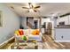 Relaxing living room with hardwood floors, an adjacent kitchen, and staircase access to the next level at 7750 Carnegie Dr, Fairburn, GA 30213