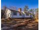 Charming home with a brick foundation, chimney, and an attached garage on a wooded lot at 11511 Highway 92, Woodstock, GA 30188