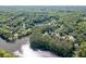 An aerial view of lakeside community homes surrounded by mature green trees with lake views and a community pool at 2930 Aquitania Ln, Cumming, GA 30040