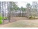 Large backyard surrounded by trees and with a fire pit and serene lake views at 2930 Aquitania Ln, Cumming, GA 30040