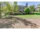 Grassy backyard with trees and the back of the home featuring an elevated porch at 2930 Aquitania Ln, Cumming, GA 30040