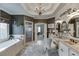 Bright bathroom featuring double sinks, a soaking tub, a separate shower, and elegant decor at 2930 Aquitania Ln, Cumming, GA 30040