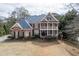 A beautiful two-story brick home with a double balcony and lush landscaping offering classic architectural details at 2930 Aquitania Ln, Cumming, GA 30040