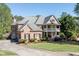 Charming two-story brick home with a double-decker porch, landscaped yard, and driveway at 2930 Aquitania Ln, Cumming, GA 30040