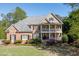Stately two-story brick home with a manicured front yard, balcony, and classic architectural details at 2930 Aquitania Ln, Cumming, GA 30040