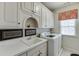 Spacious laundry room with built-in cabinets and modern washer and dryer at 2930 Aquitania Ln, Cumming, GA 30040