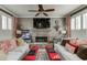 Cozy living room with stone fireplace, ceiling fan, and plantation shutters at 2930 Aquitania Ln, Cumming, GA 30040