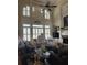 Spacious living room with high windows, a ceiling fan, and a warm fireplace at 2930 Aquitania Ln, Cumming, GA 30040