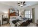Comfortable primary bedroom with a four-poster bed, carpeted floors and window with shutters at 2930 Aquitania Ln, Cumming, GA 30040