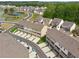 Aerial view of new home community featuring townhomes, a pond, and wooded areas at 4259 Baden Aly, Duluth, GA 30097