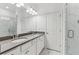 Bright bathroom featuring double vanity with gray countertop, marble floors, and a glass-enclosed shower at 4259 Baden Aly, Duluth, GA 30097
