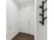 Bright entryway with a white door, dark wood floors, and a modern coat rack for a welcoming space at 4259 Baden Aly, Duluth, GA 30097