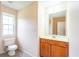 Bright bathroom features a white toilet and a vanity with wood cabinets and a large mirror at 60 Heritage Keep, Covington, GA 30016