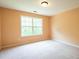 A empty bedroom with large windows providing natural light to the carpeted space, ideal for relaxation at 60 Heritage Keep, Covington, GA 30016