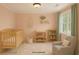 Cozy Bedroom with a crib, changing table, accent rug, and plenty of natural light from the window at 60 Heritage Keep, Covington, GA 30016